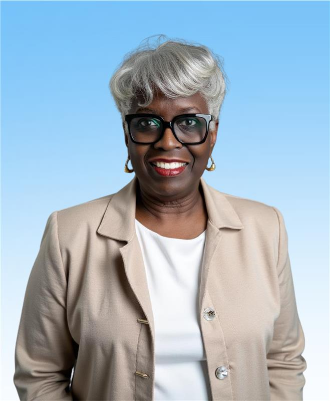 Woman in a tan suit sitting in front of a blue gradient background