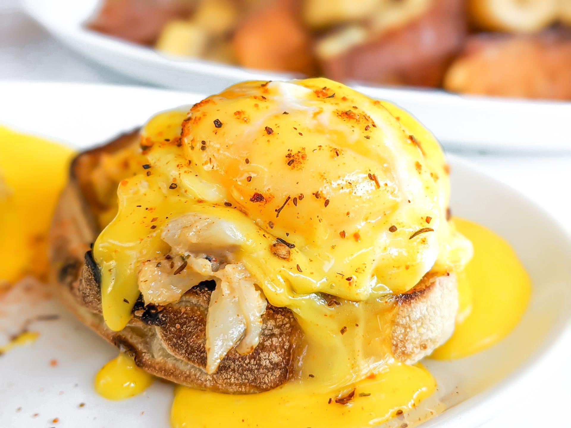 A close up of a sandwich with eggs and cheese on a plate.