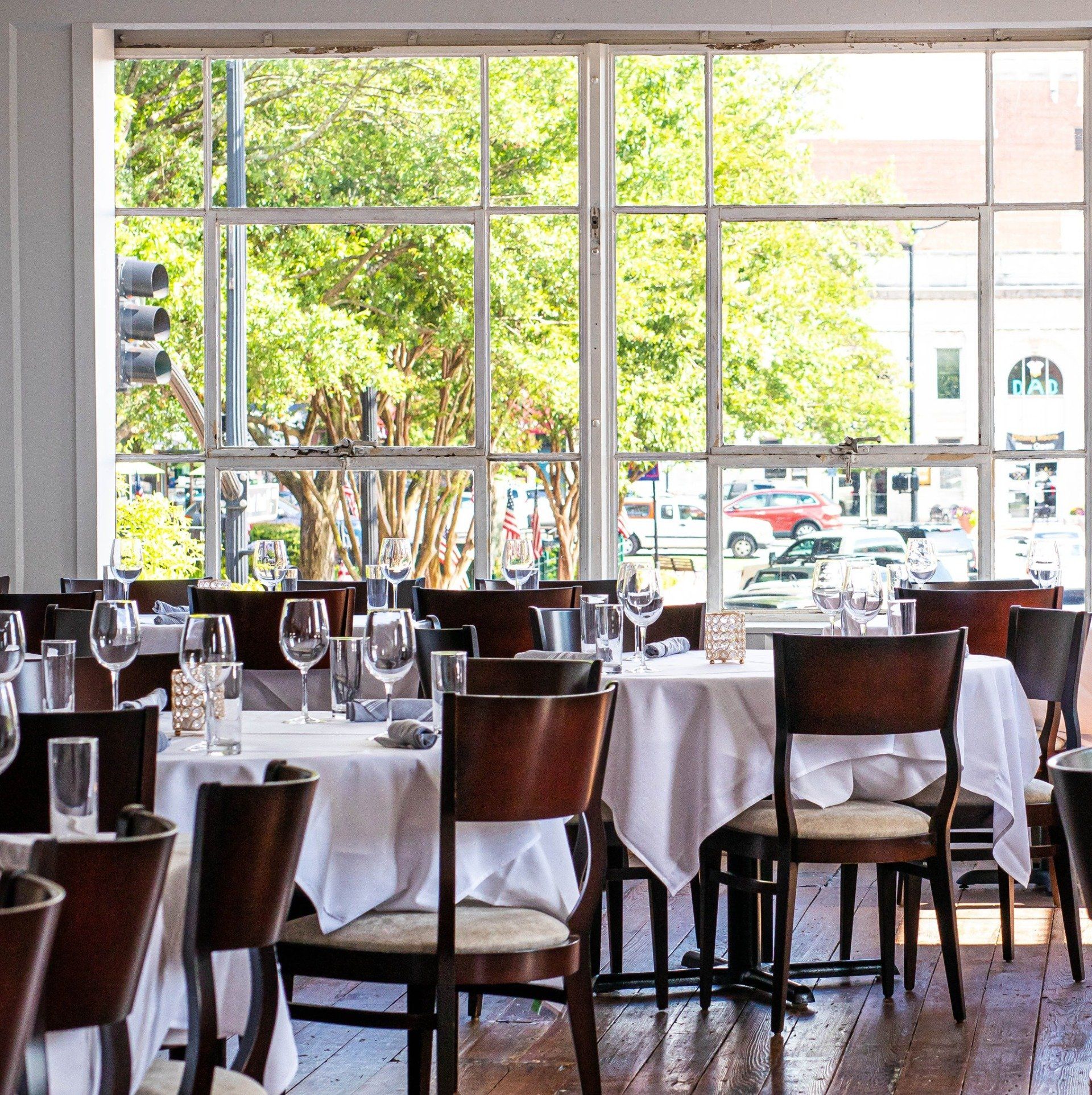 A restaurant with tables and chairs and a large window