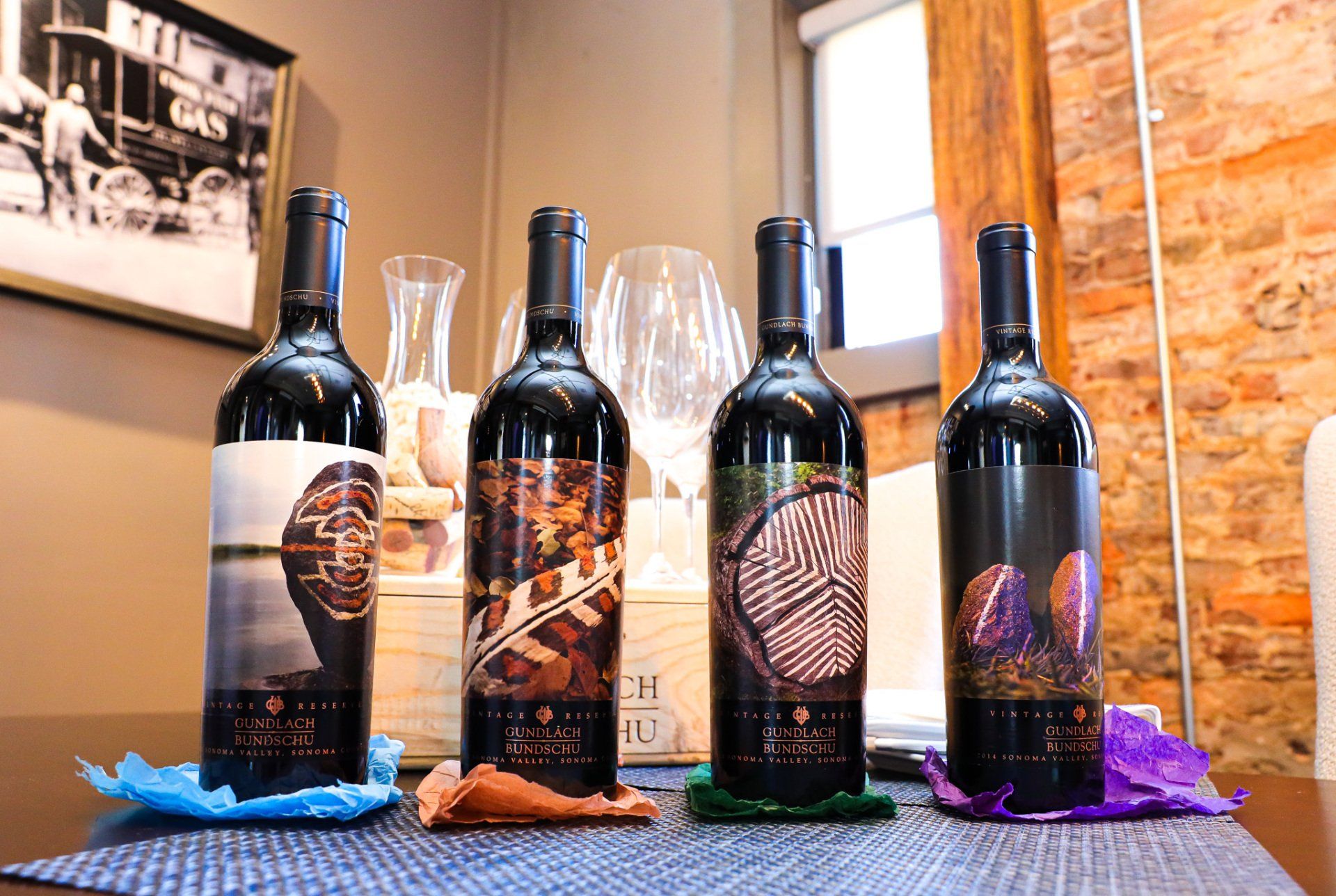 Four bottles of wine are sitting on a table.