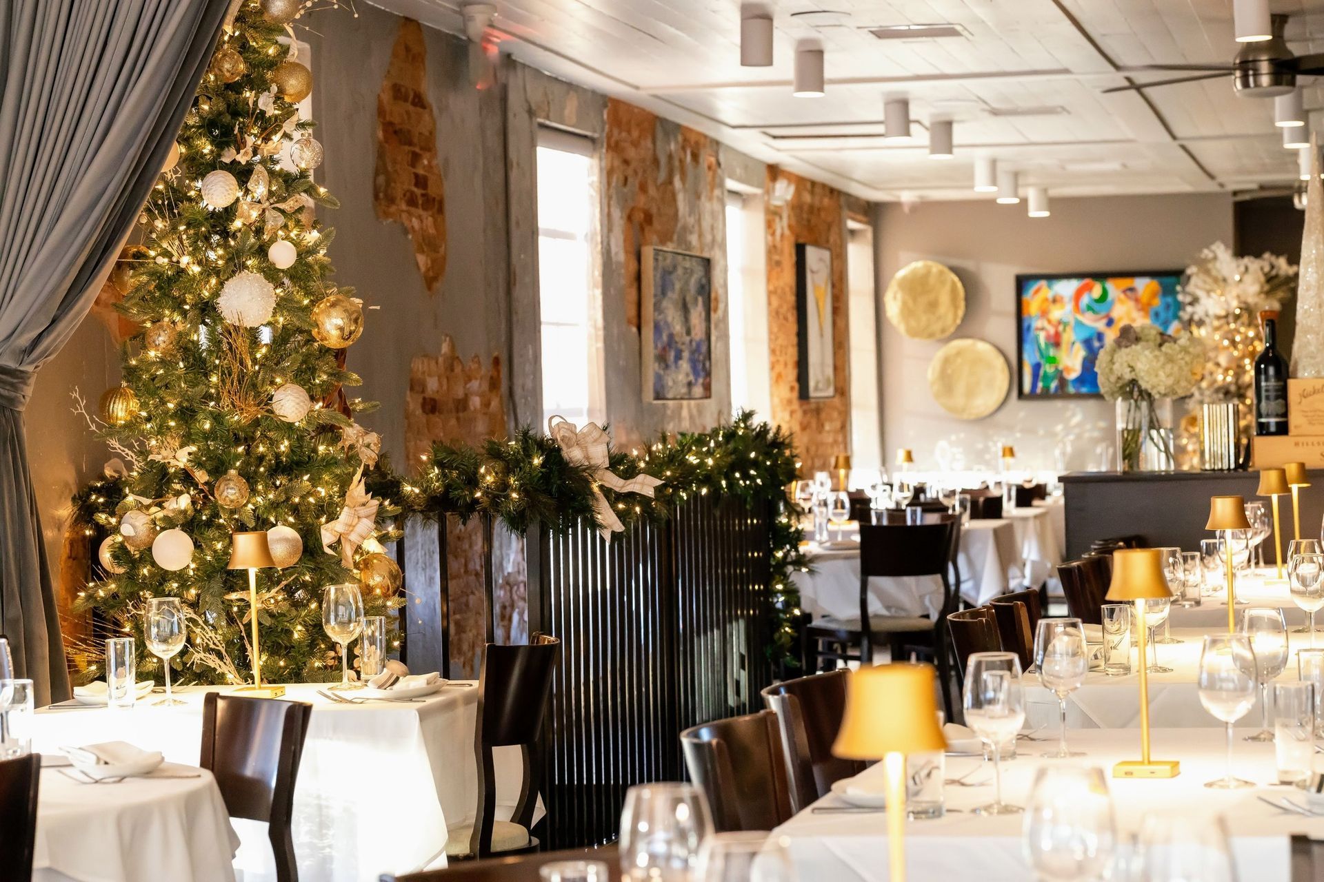 A restaurant filled with tables and chairs and a christmas tree.