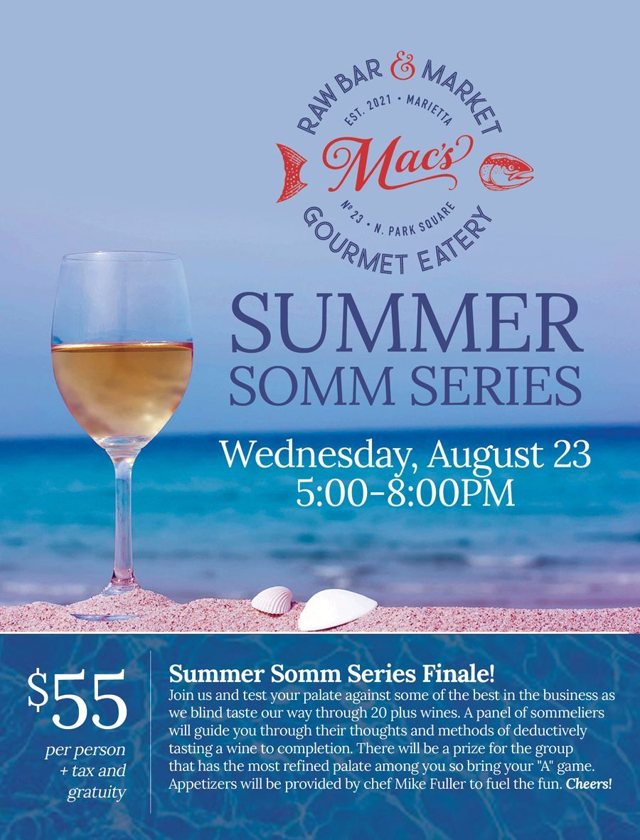 A poster for mac 's gourmet eatery shows a glass of wine on the beach.