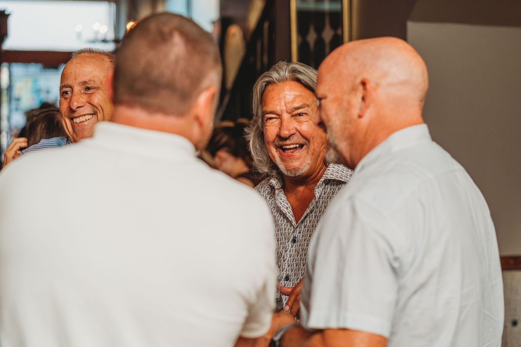 A group of men are talking at Mac's