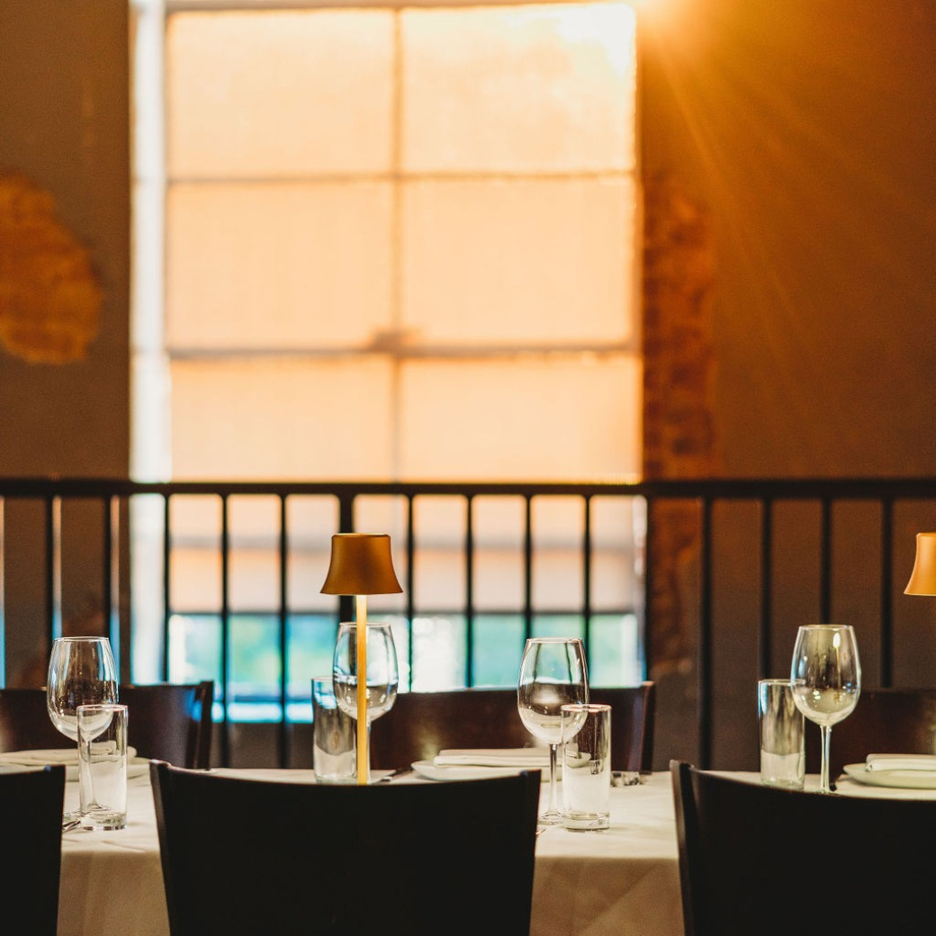 A restaurant with tables and chairs and glasses of wine