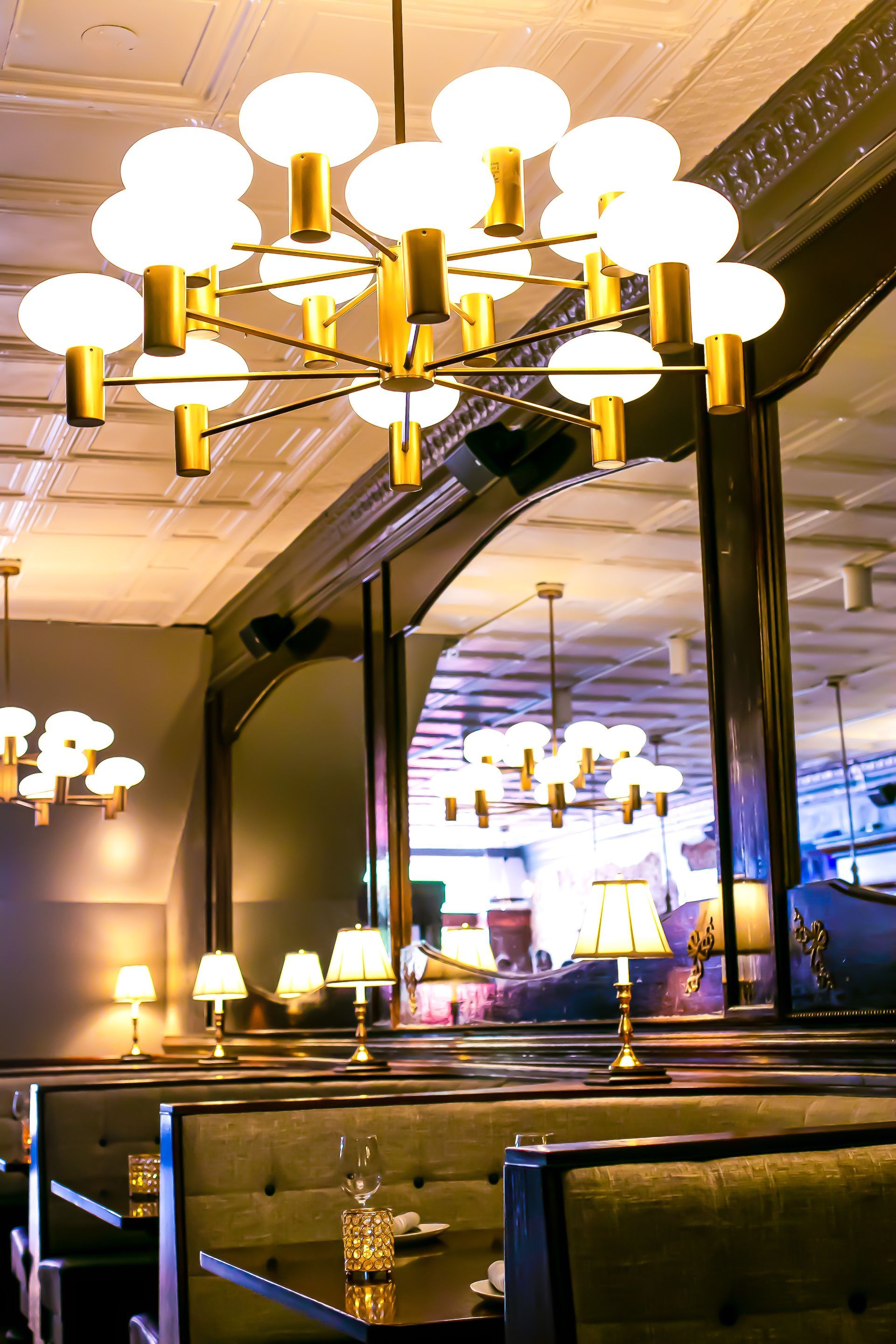 A restaurant with tables and a chandelier hanging from the ceiling