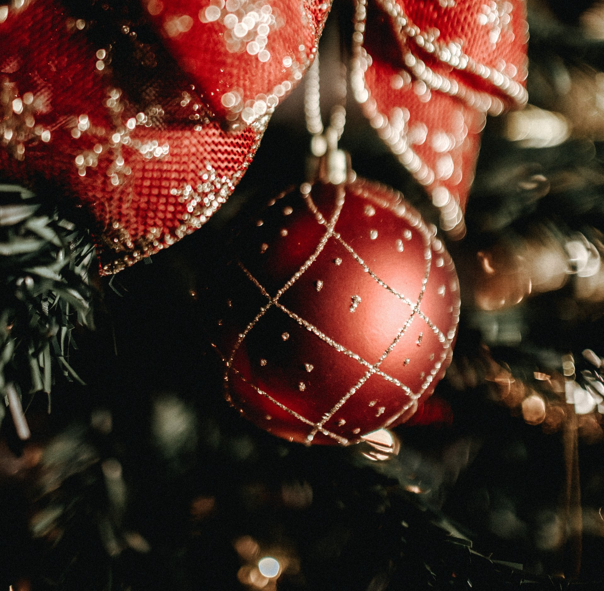 A close up of a red christmas ornament on a tree
