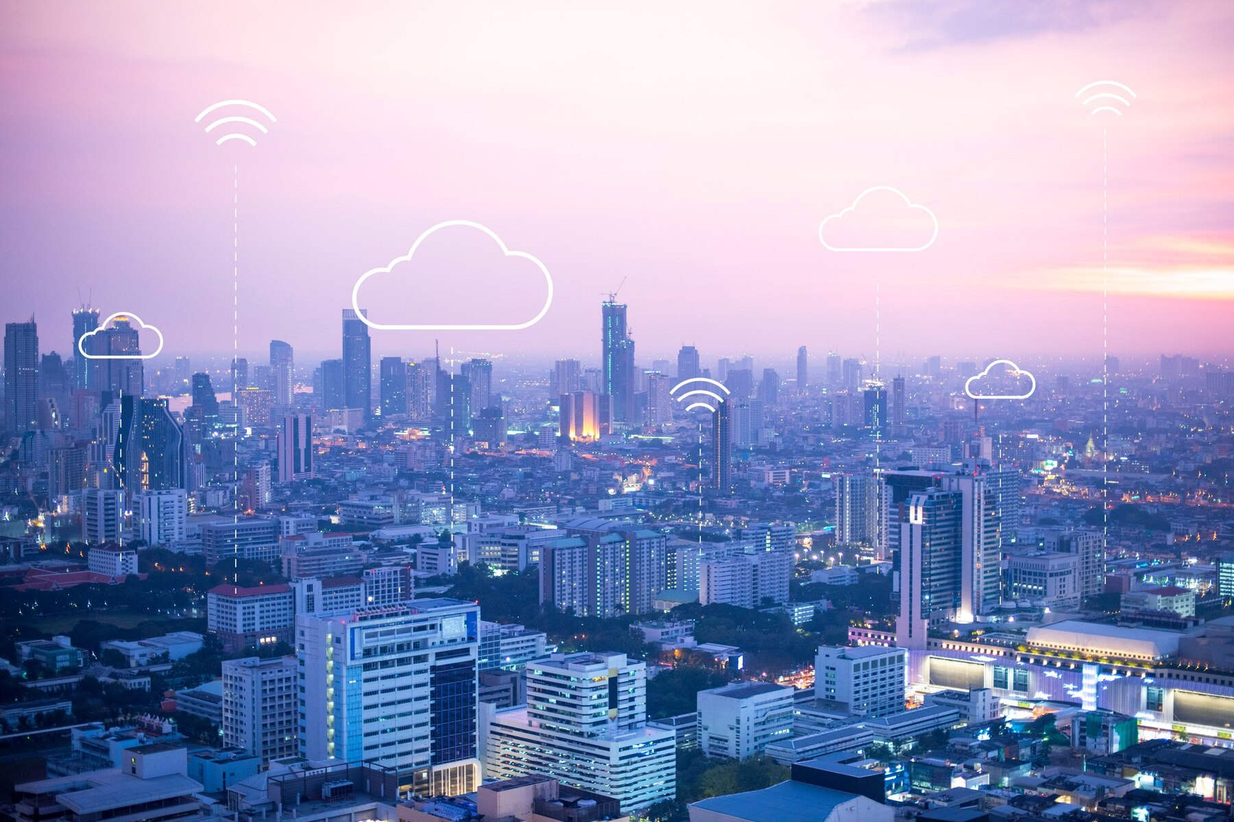 City skyline at dusk with pastel pink sky and cloud network icons overlaying buildings