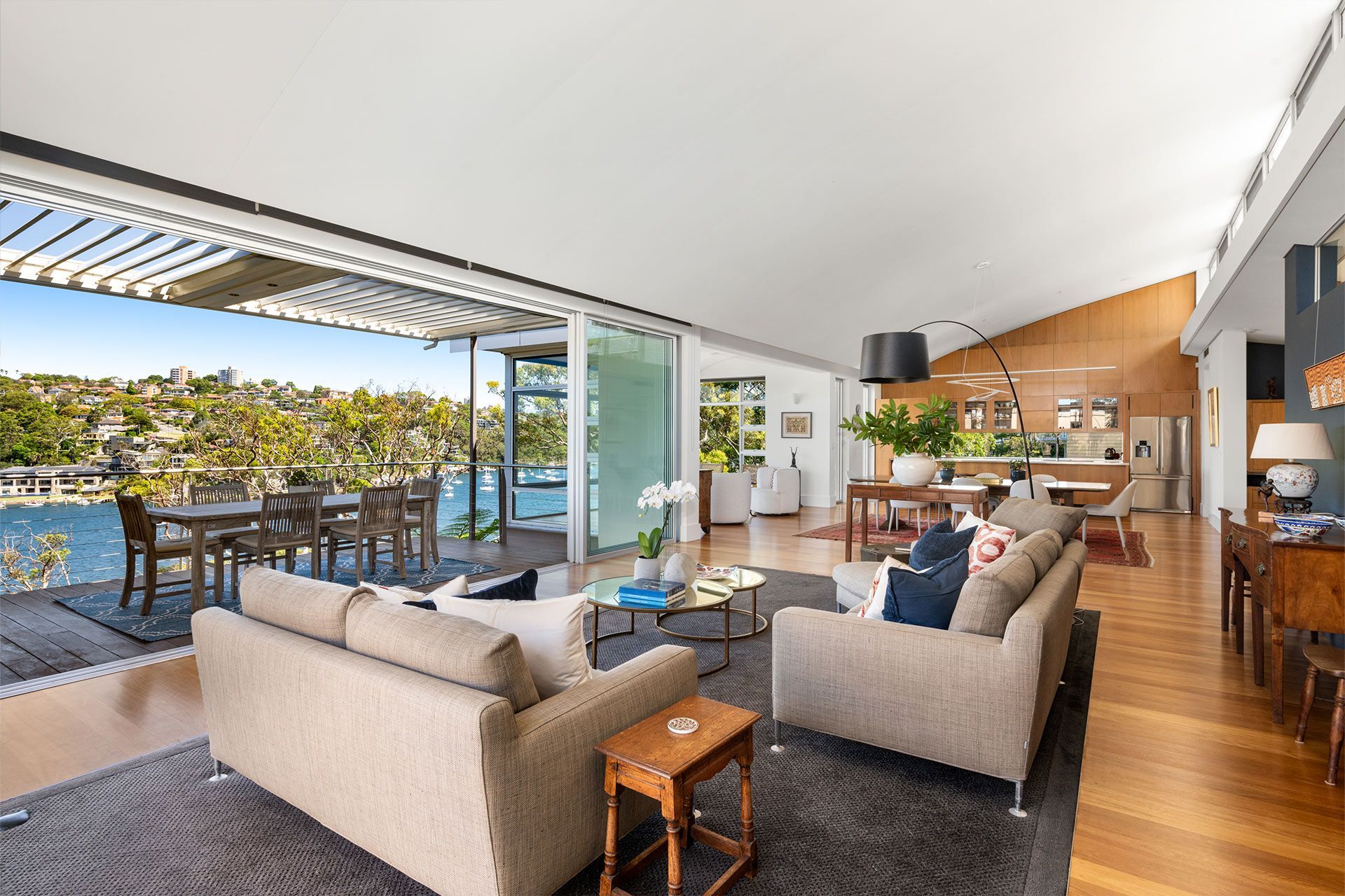 A living room with a couch and chairs and a view of the water.
