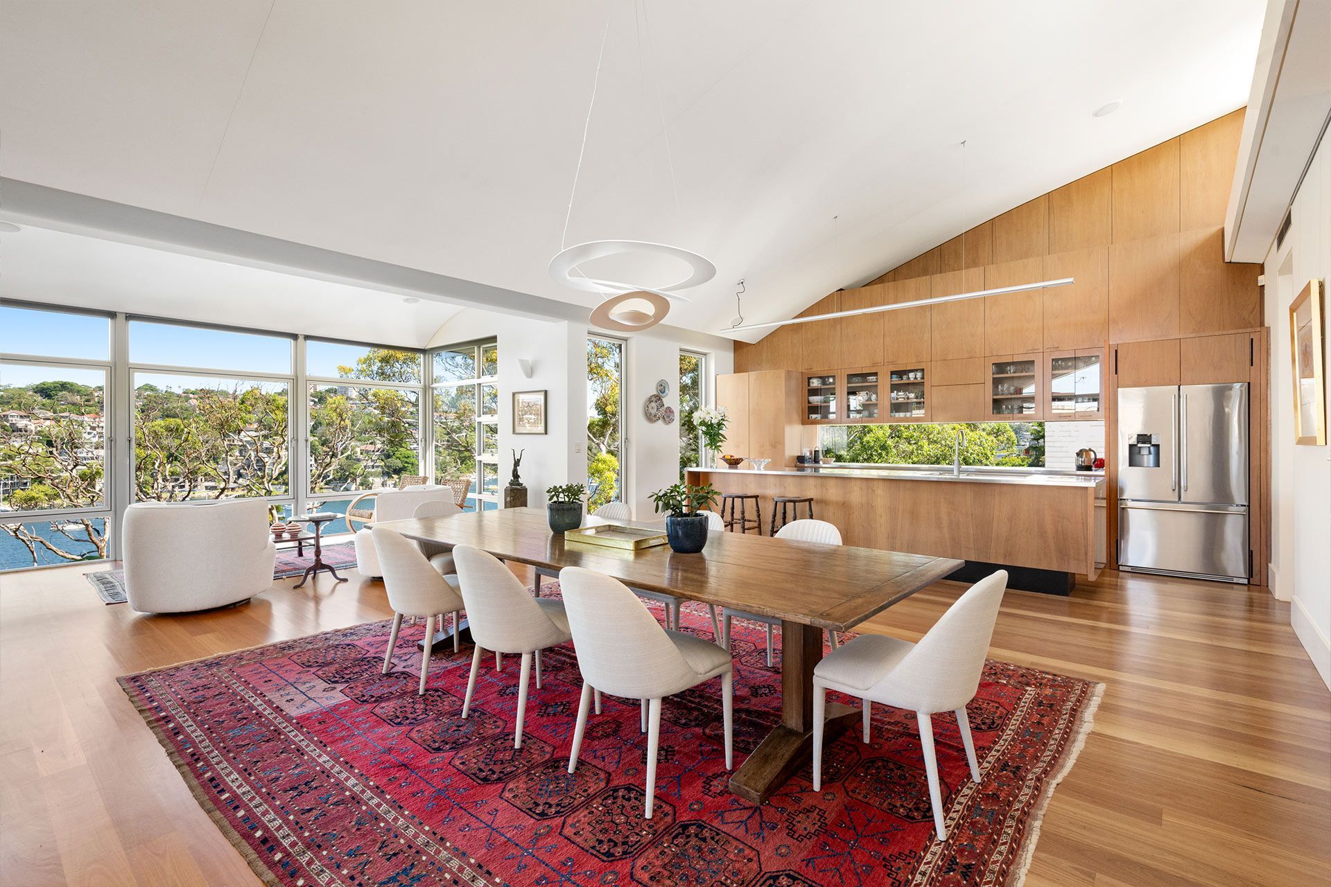 A dining room with a table and chairs and a rug.