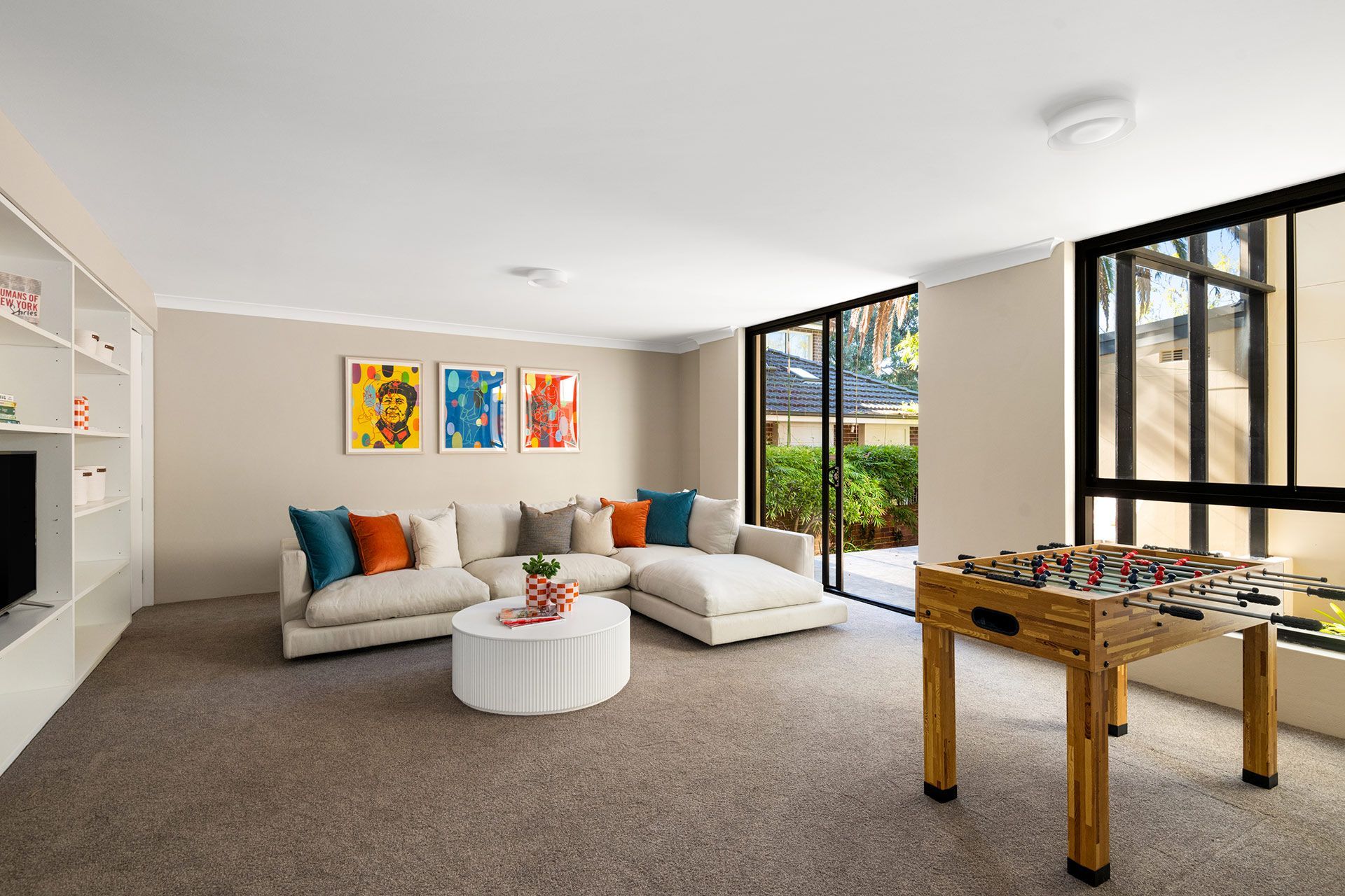 A living room with a couch , table , and foosball table.