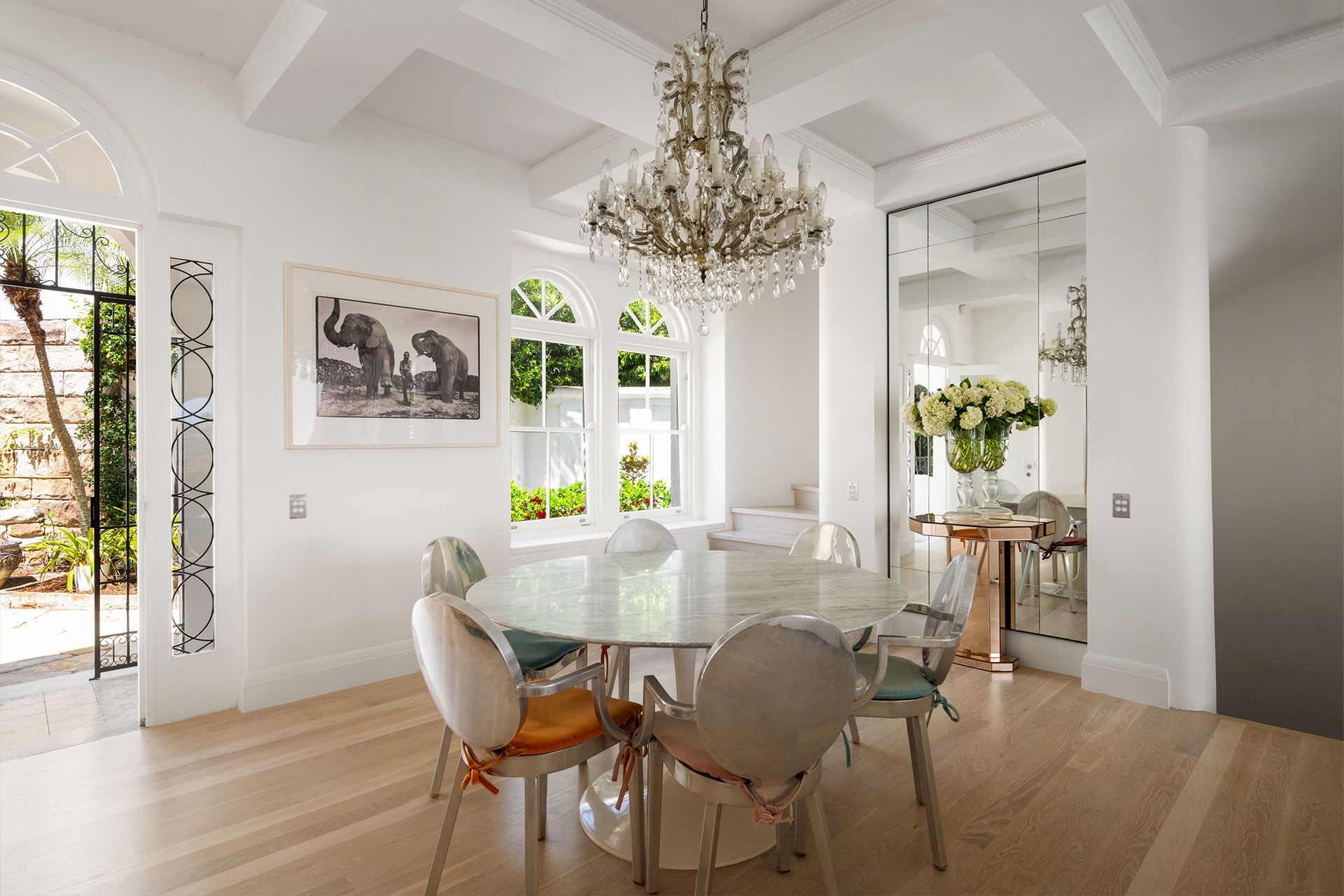A dining room with a table and chairs and a chandelier. Mosman.