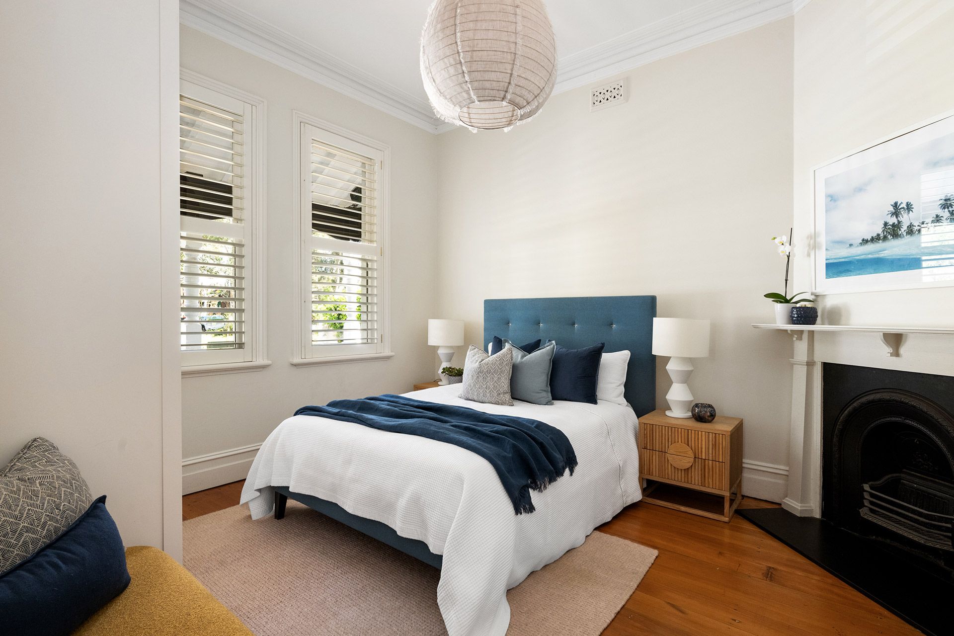A bedroom with a large bed and a fireplace.