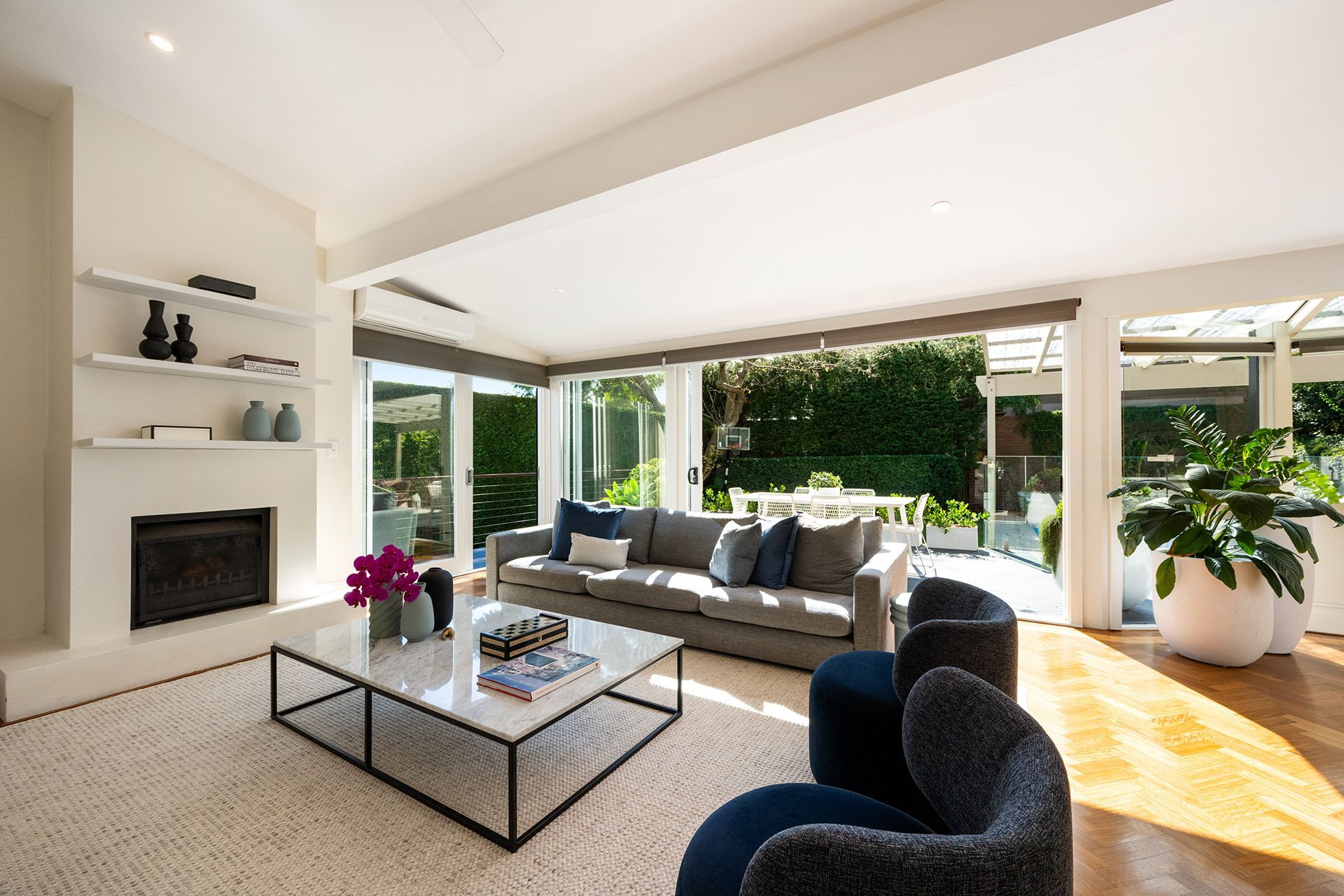 A living room with a couch , chairs , coffee table and fireplace.