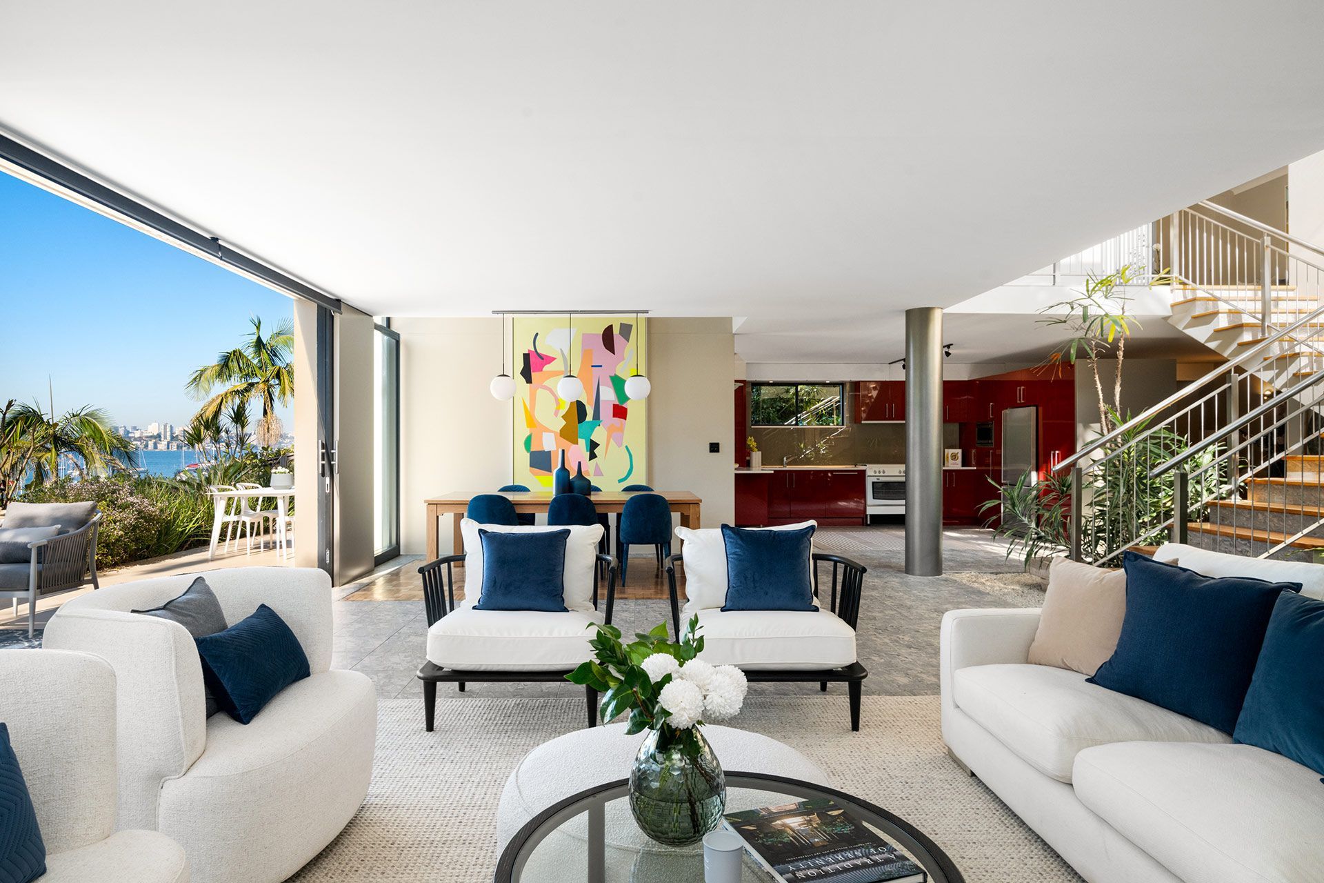 A living room filled with furniture and a table with a vase of flowers on it.