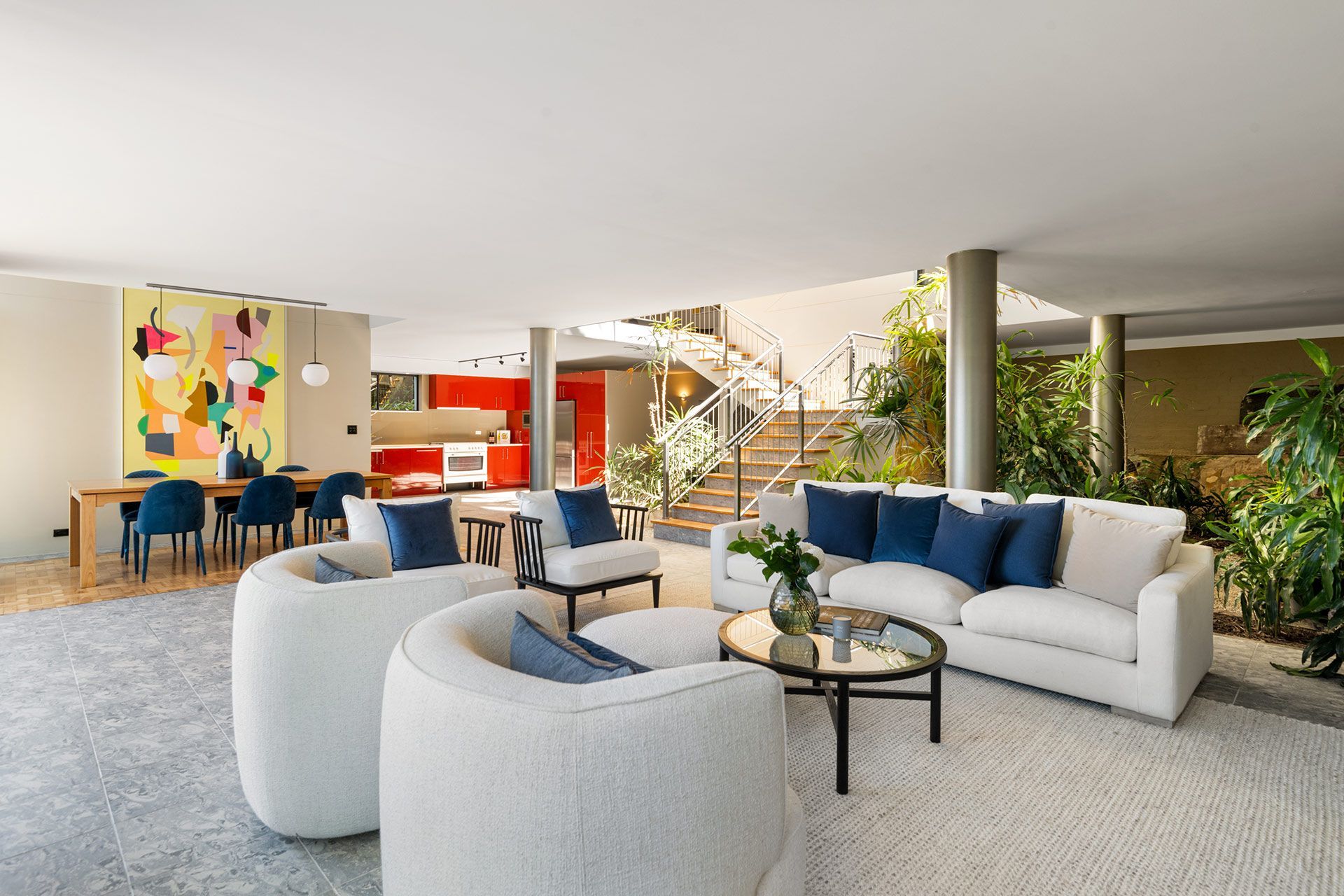 A living room with a couch , chairs , and a table.