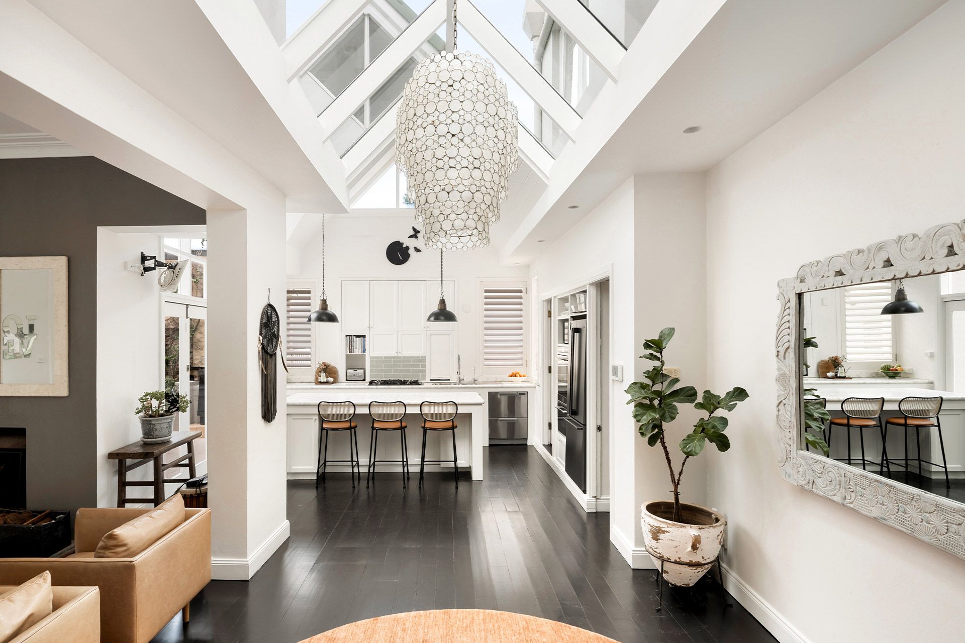 A living room and kitchen in a house with a skylight.