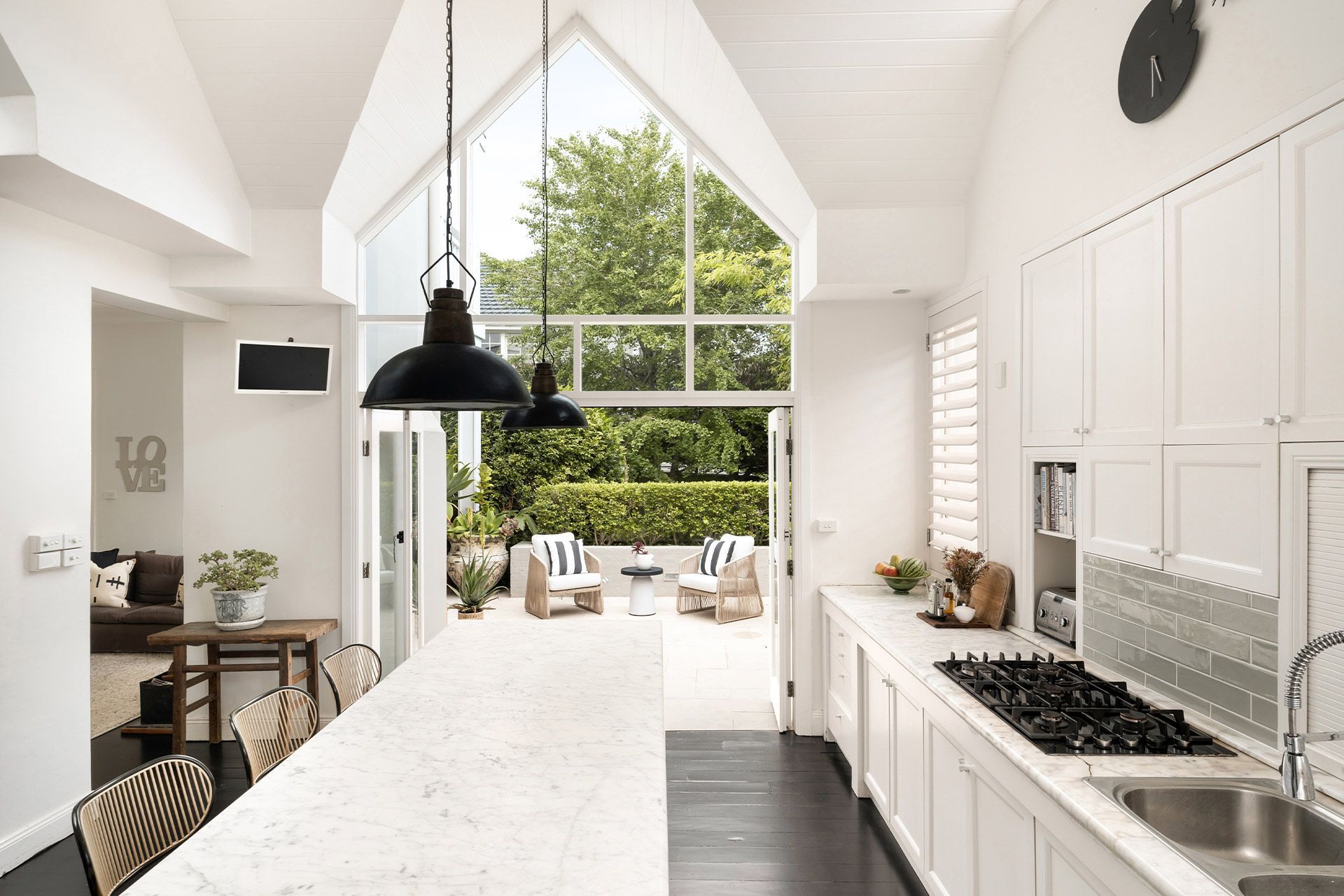 A kitchen with a large island and a clock on the wall