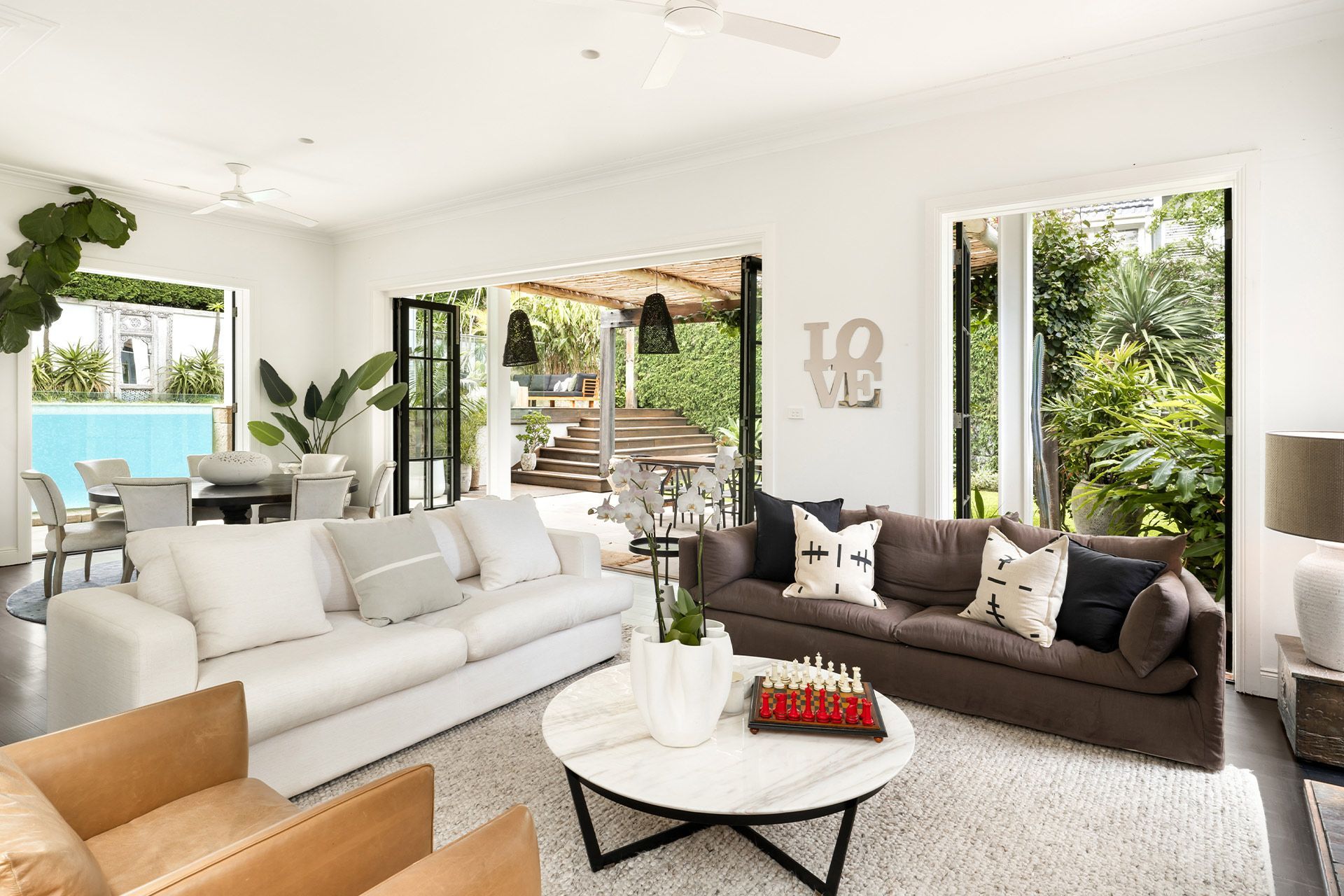 A living room with two couches , a coffee table , and a sign that says love.