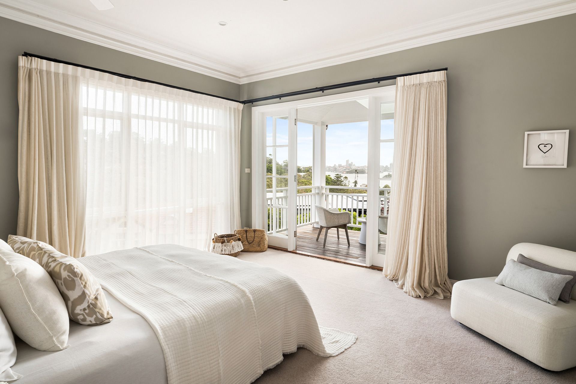 A bedroom with a bed , chair and sliding glass doors leading to a balcony.