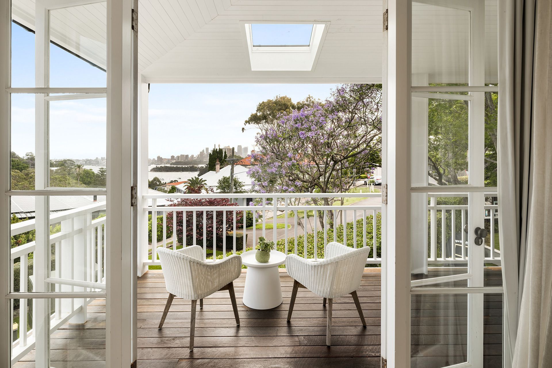 There is a balcony with two chairs and a table on it.