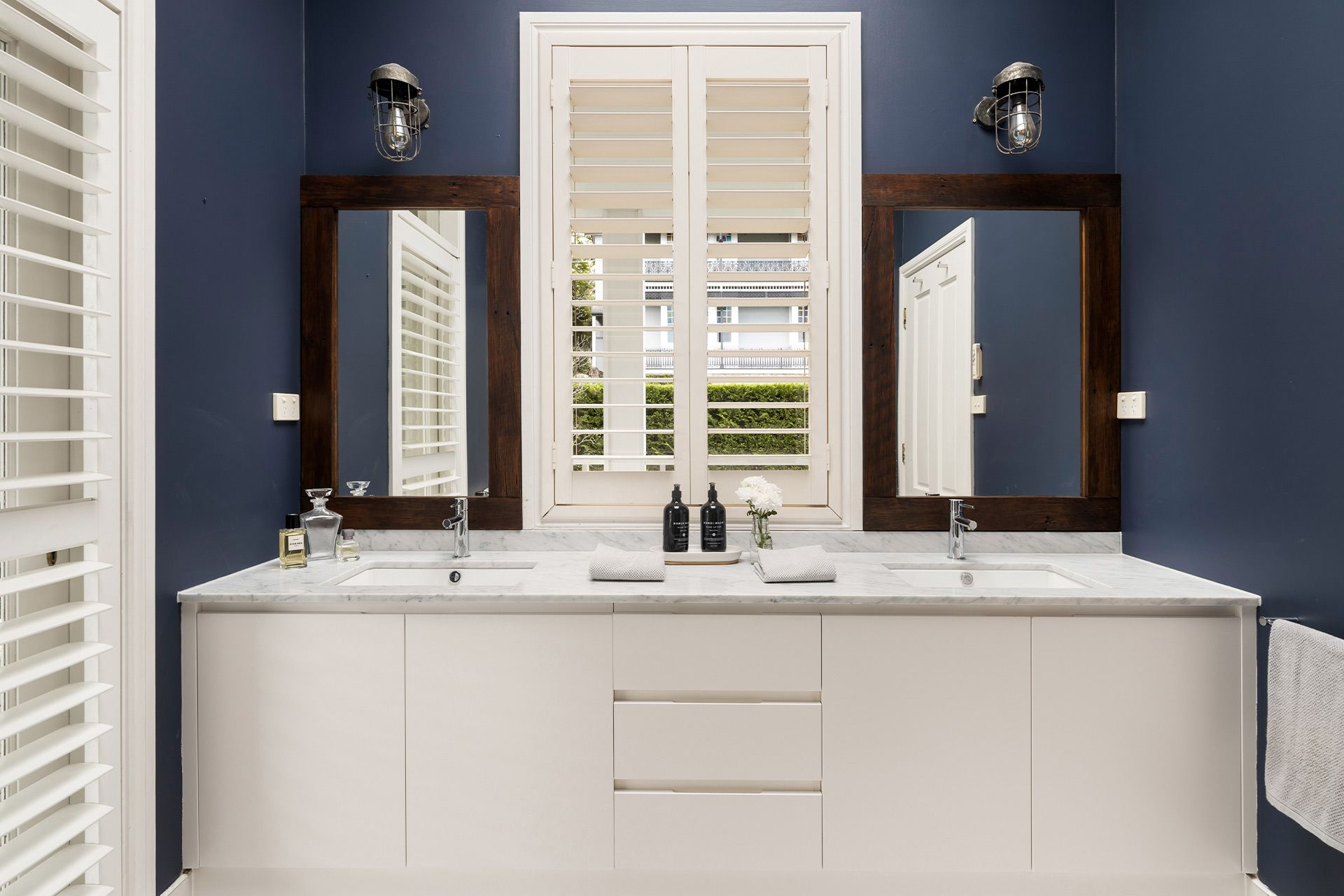 A bathroom with two sinks and two mirrors.