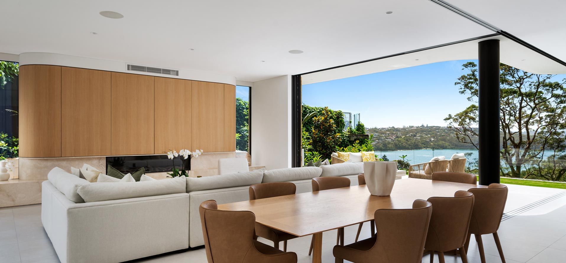 A living room with a table and chairs and a view of a lake