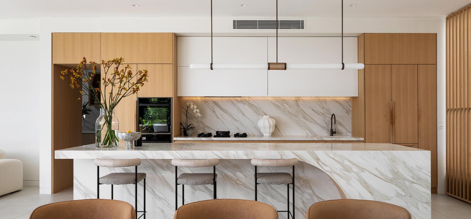 A kitchen with marble counter tops , wooden cabinets , and a large island.