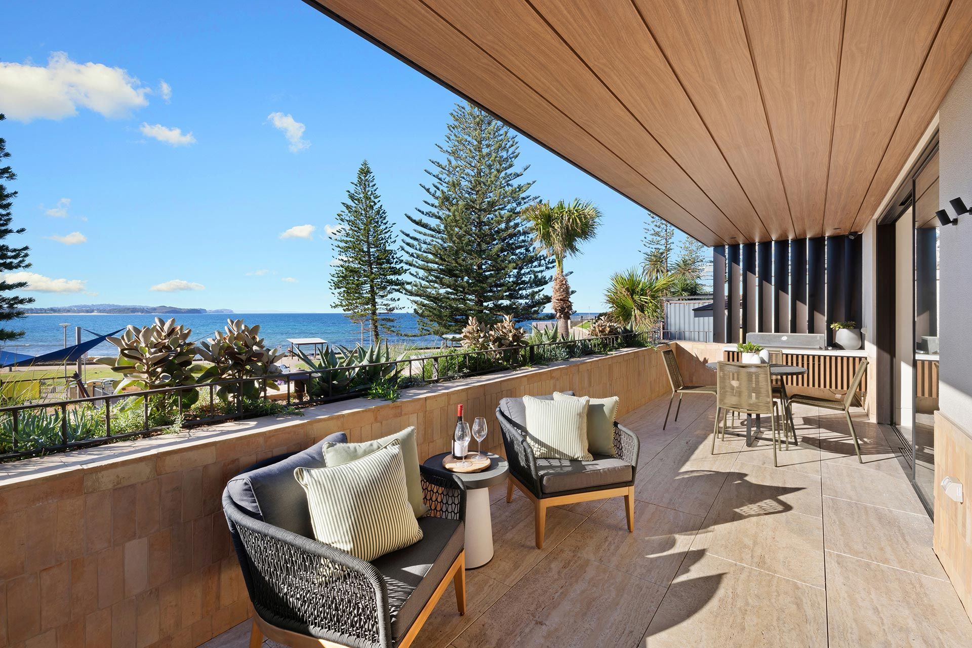 A balcony with a couch and chairs overlooking the ocean