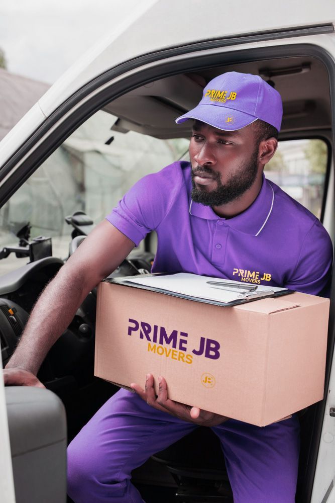 A man in a purple uniform is sitting in a car holding a box.