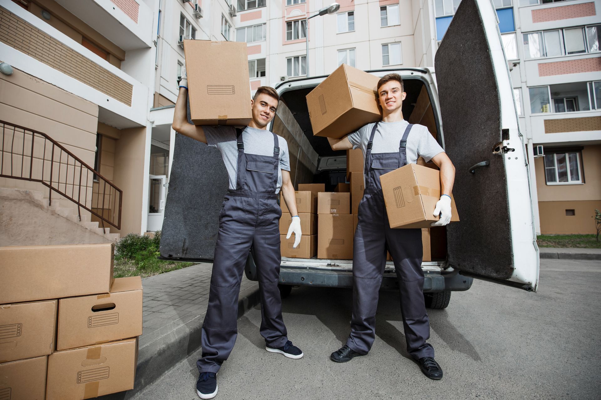 Two men are carrying boxes out of a van.