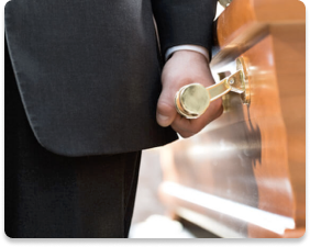 Person in a dark suit opening a wooden door with a brass handle and keyhole
