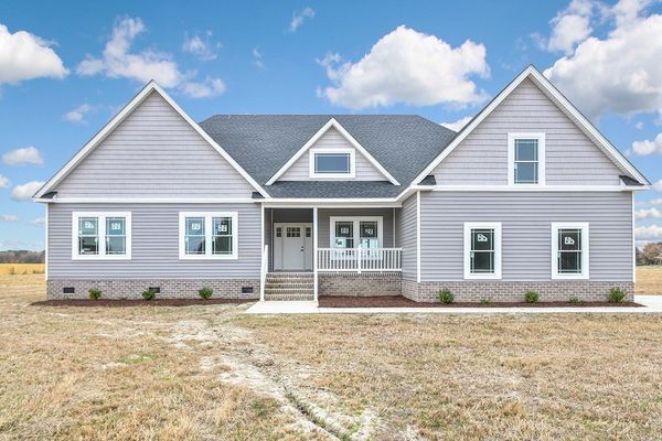 Gray house with white trim, front porch, and blue sky.