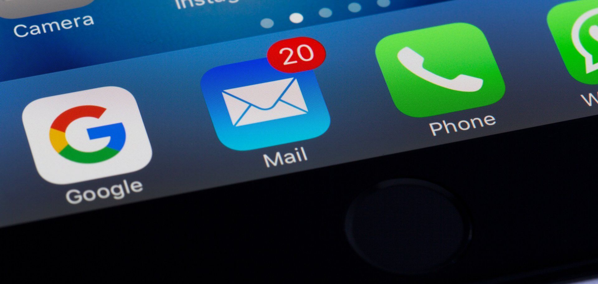 Close-up of a smartphone home screen with Google, Mail, and Phone icons on a blue background.