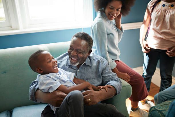 A man is sitting on a couch holding a child.