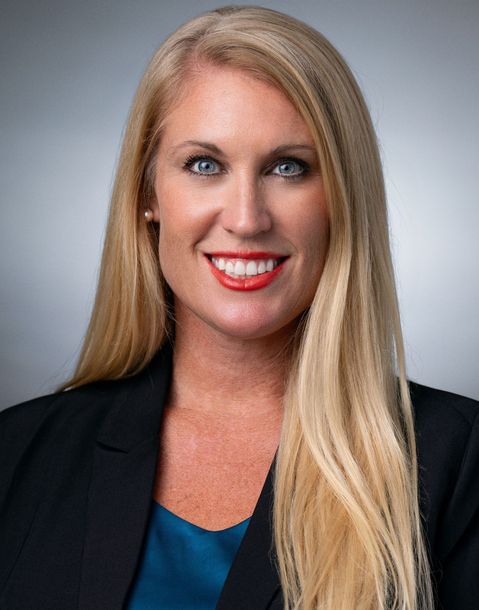 A woman with long blonde hair is wearing a black jacket and a blue shirt. A woman with long blonde hair is wearing a black jacket and a blue shirt.