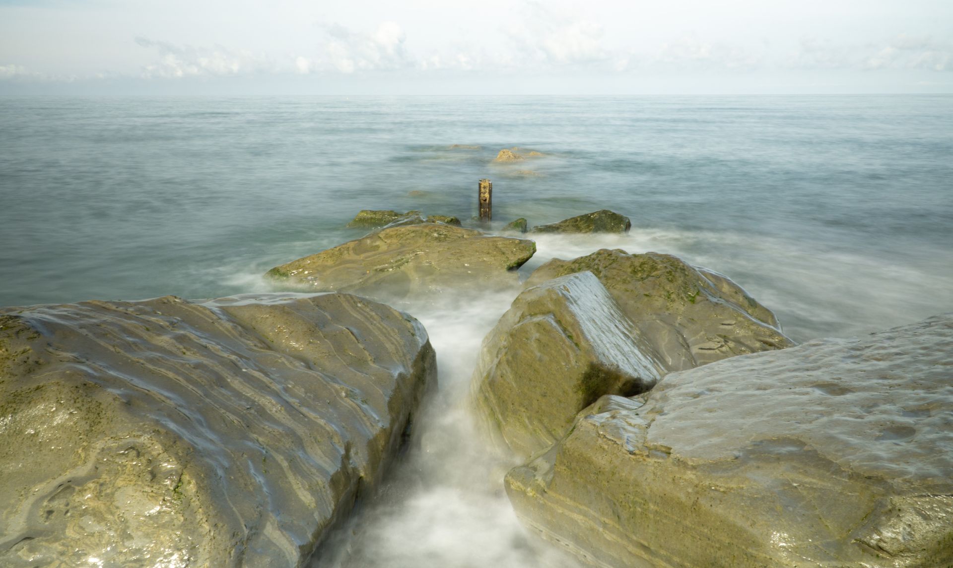 Rocks Embraced by Gentle Sea Print