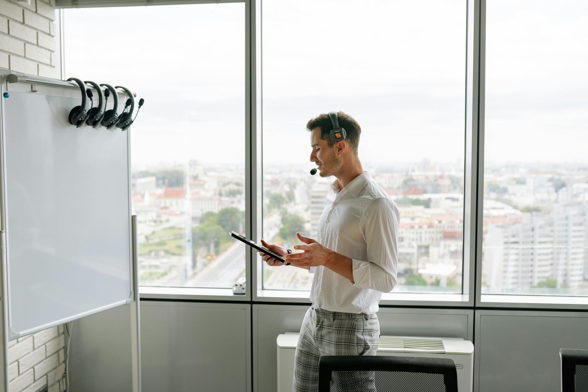 T3 Cloud Technologies man with a phone headset and a tablet looking at a blank white board while learning about data service