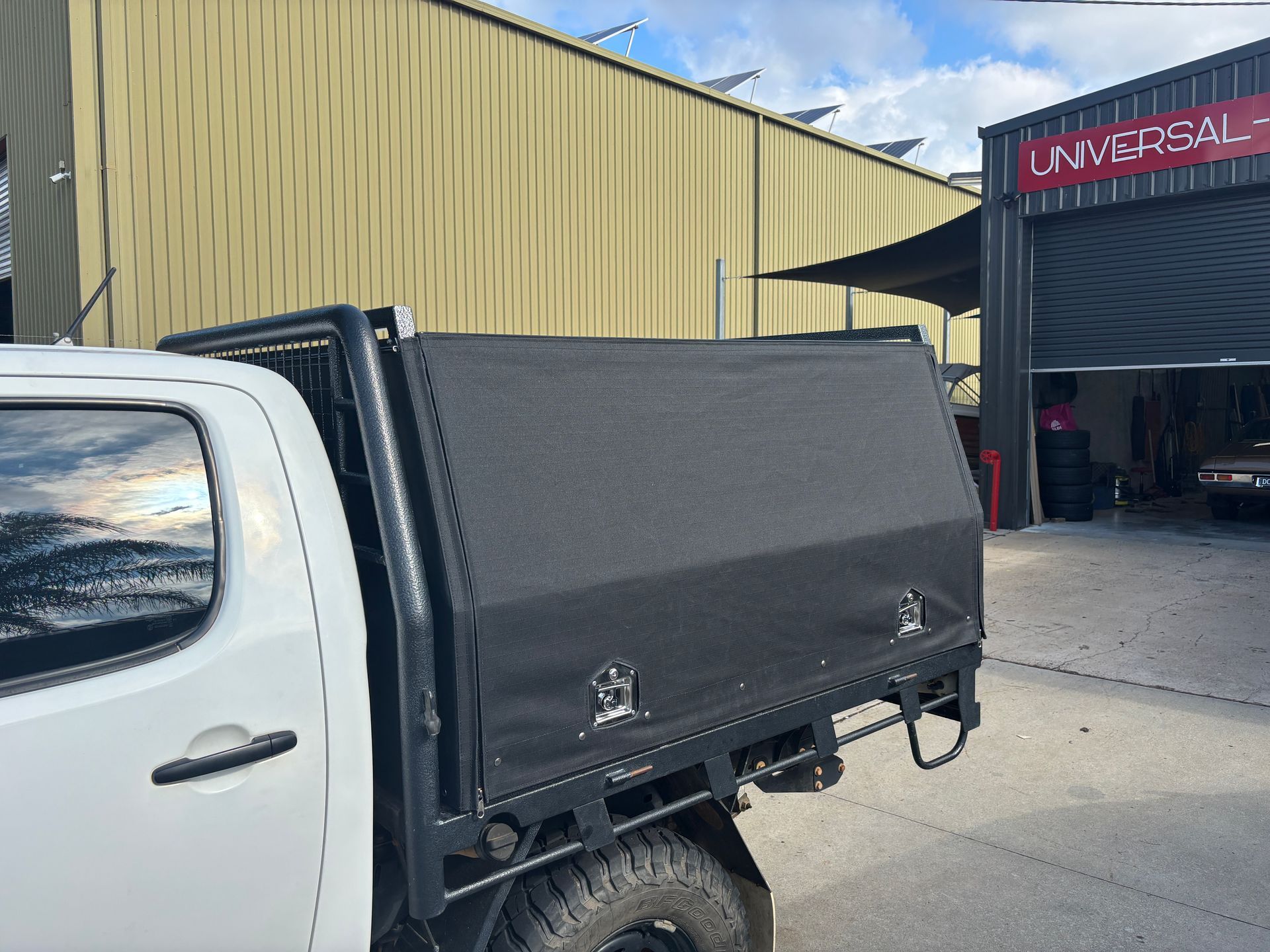 Custom black canvas press stud canopy over lockable cage