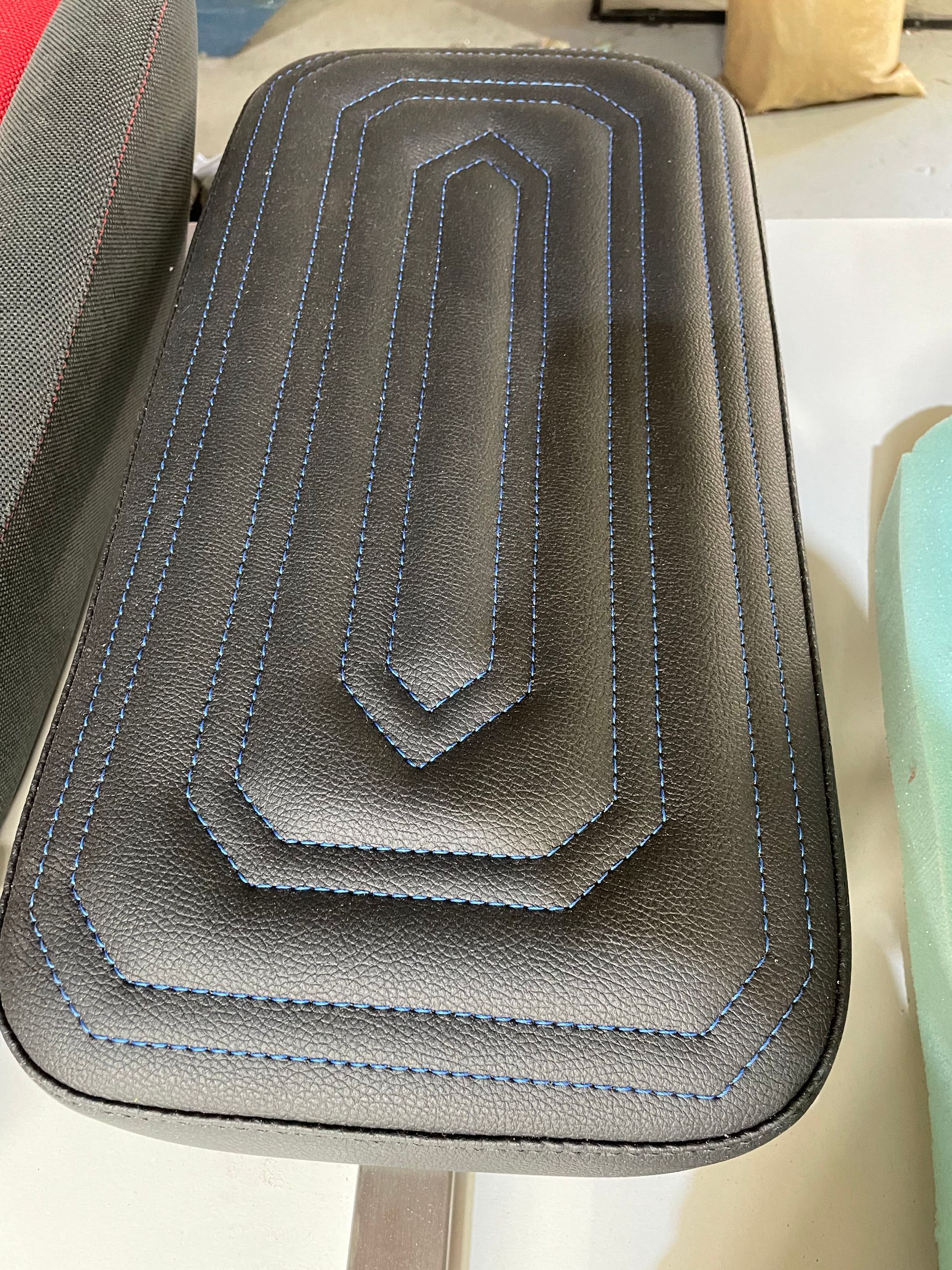 Custom designed padded cushion black vinyl with blue decorative stitch