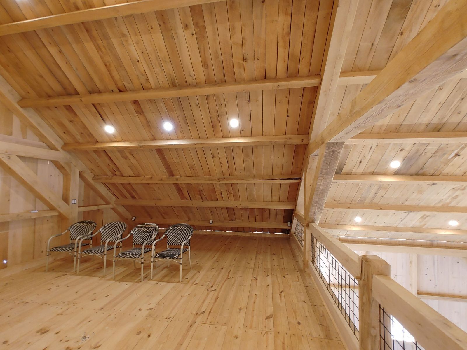 A stunning custom wooden loft space with a vaulted ceiling by CTFS