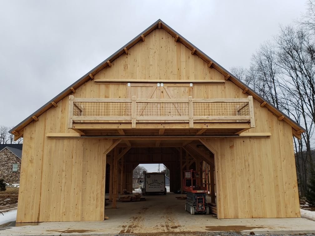 A large, light-colored wooden barn with a central open breezeway by CTFS. 