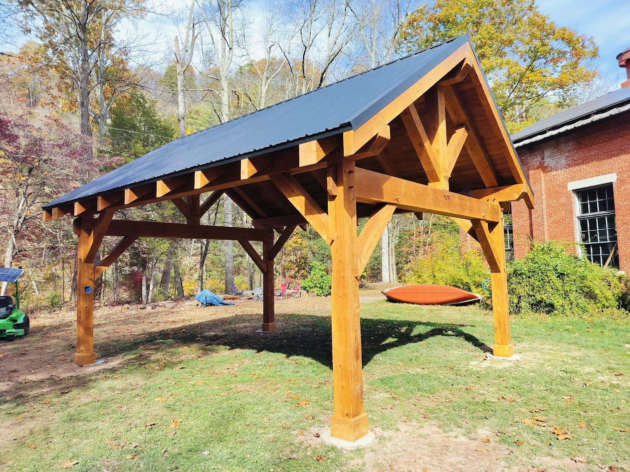 A timber-frame pavilion with a metal roof by Central Timber Frame Supply available for wholesale across the United States