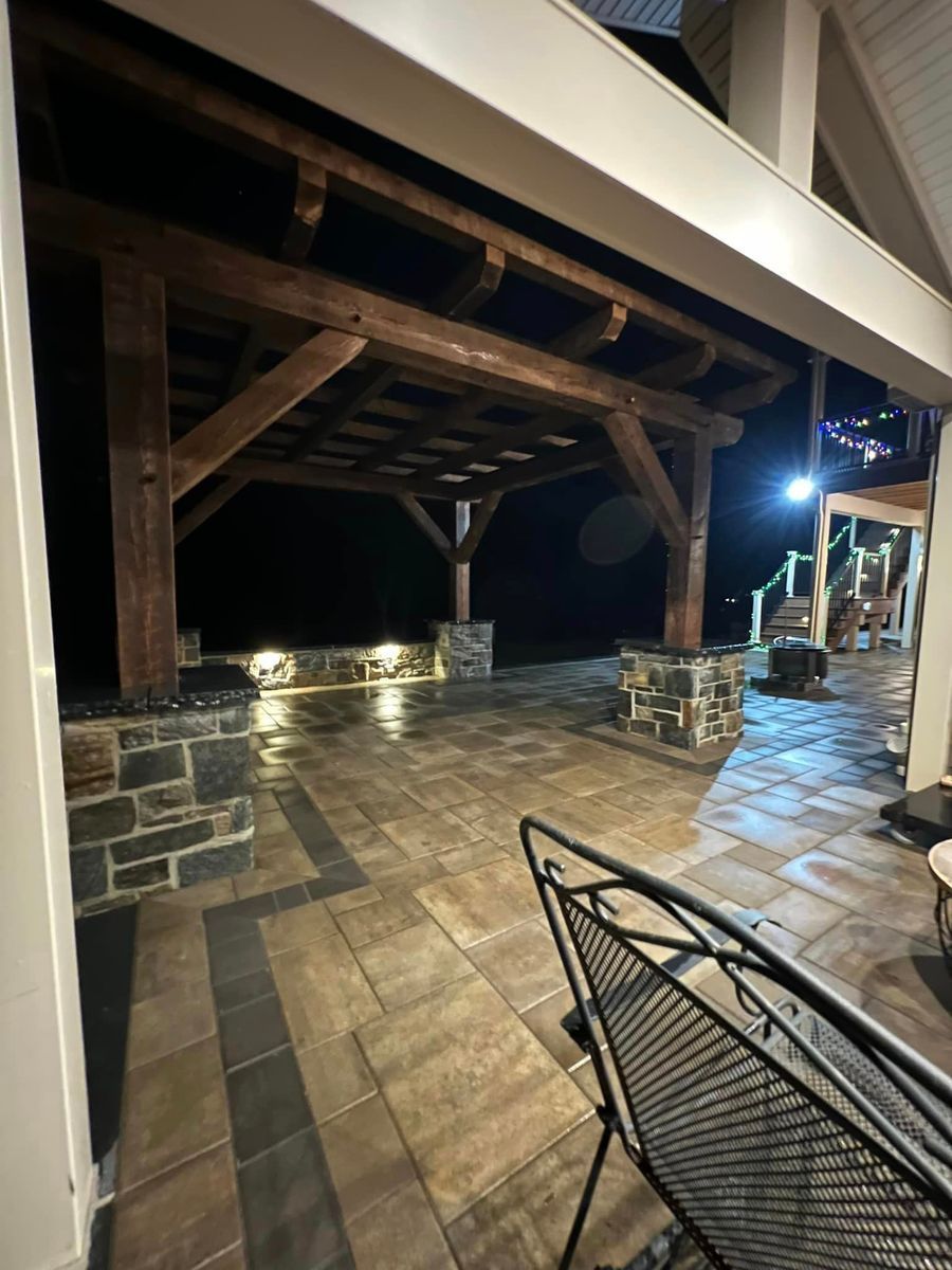 Central Timber Frame Supply built wood-framed pergola and recessed outdoor lighting, viewed from under a porch.