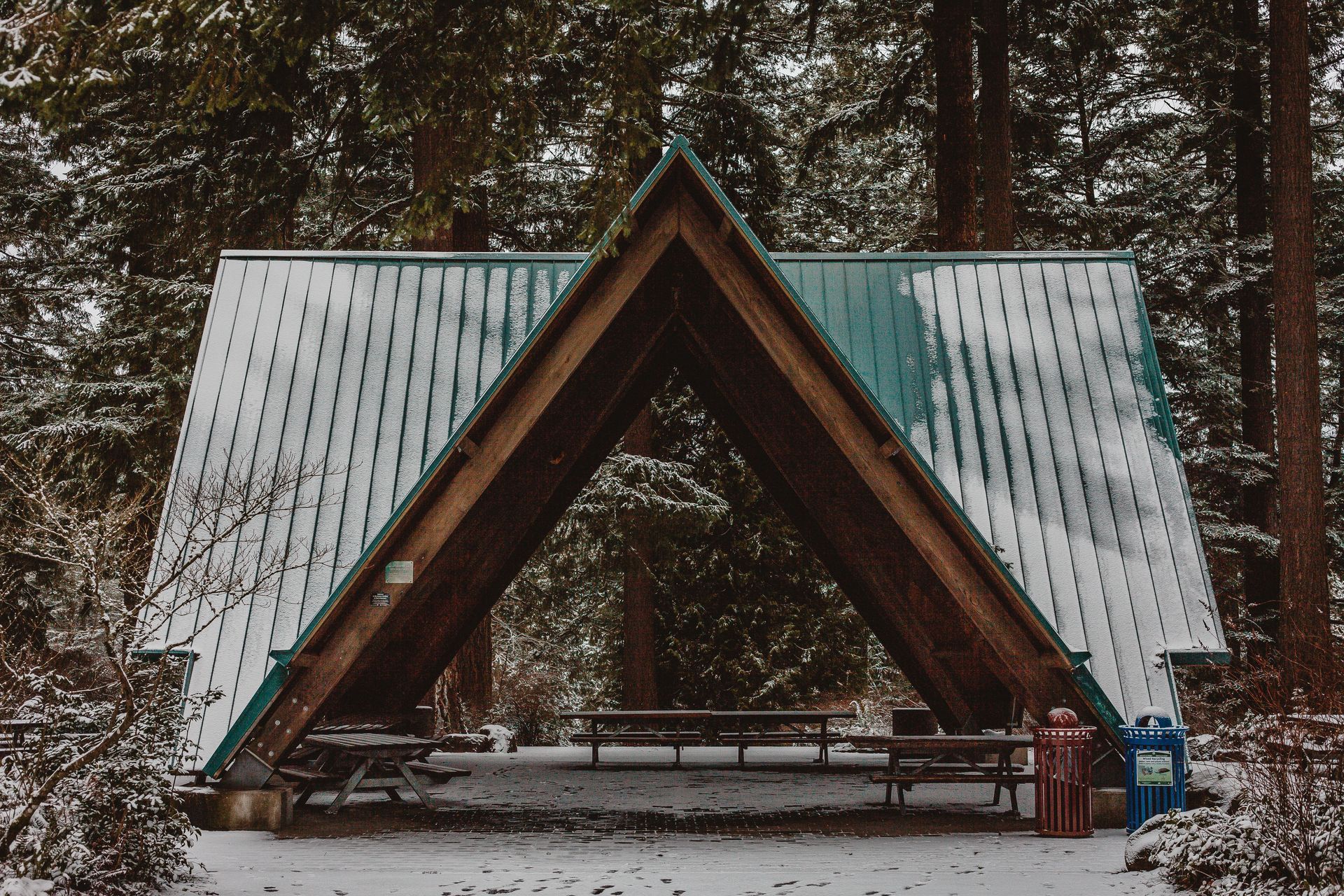Timber pavilion with a metal roof in a snowy Pennsylvania landscape, prepared for winter installatio