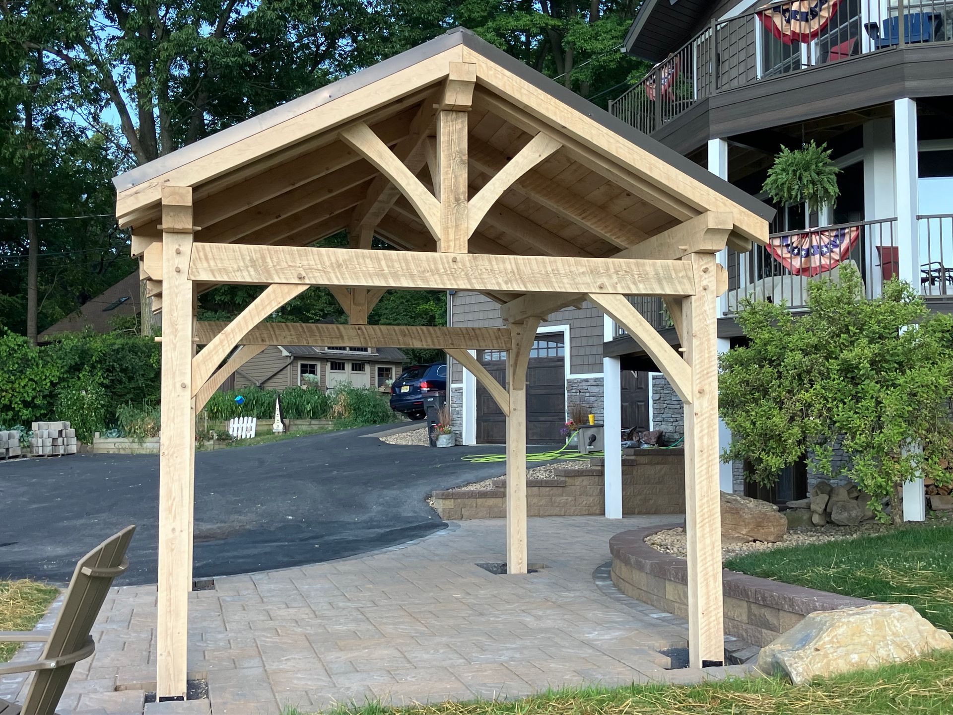 A timber frame gazebo with a gabled roof by Central Timber Frame Supply available for wholesale across the United States