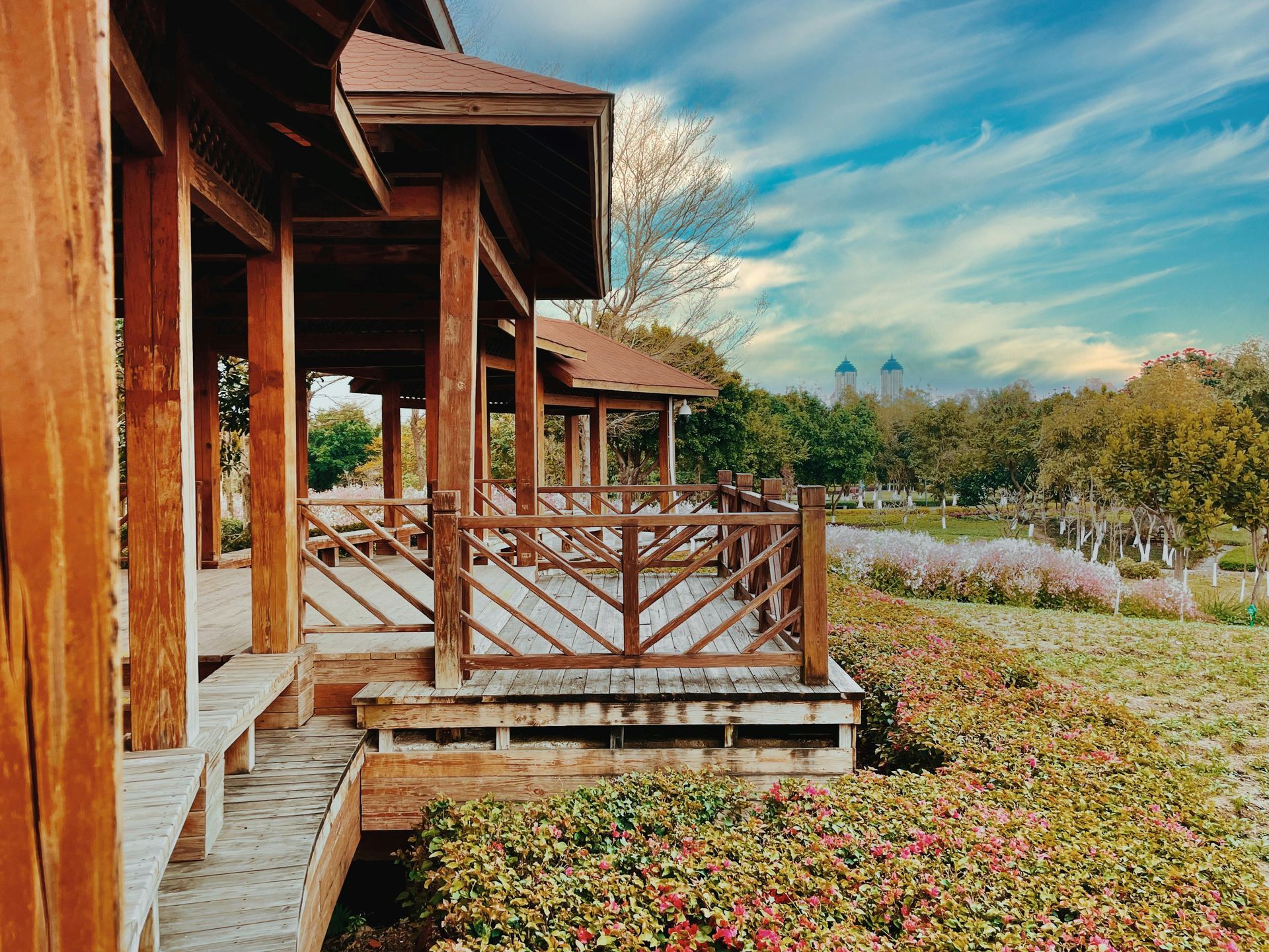Wooden porch overlooking a garden with autumn foliage and a blue sky