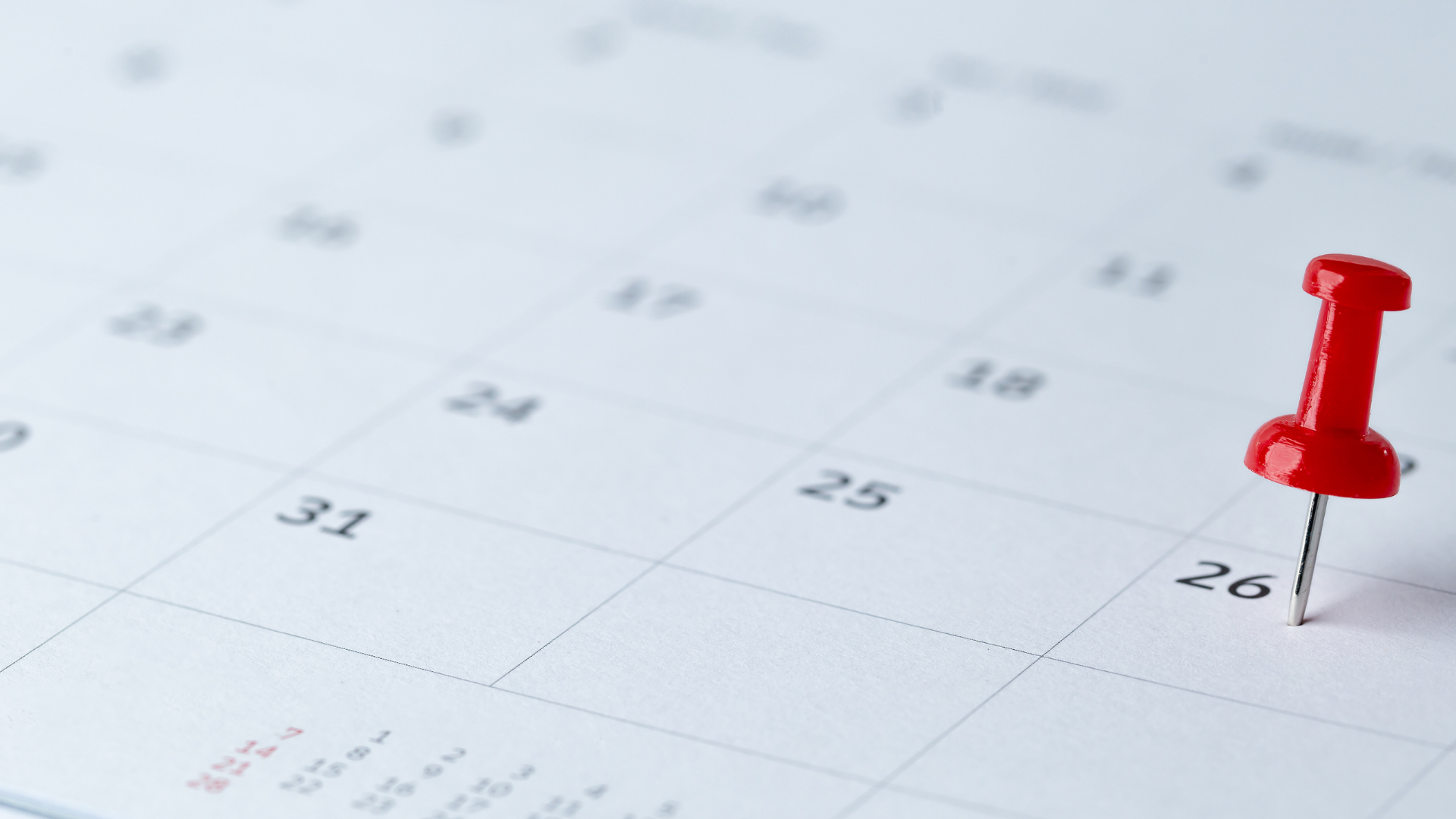 White calendar page with a red push pin marking the 26th day.