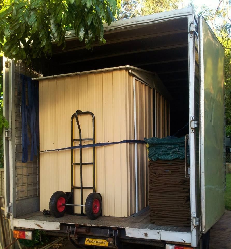 Open cargo truck loaded with stacked boxes and a hand truck on the floor — MM Removals In Nelson Bay, NSW