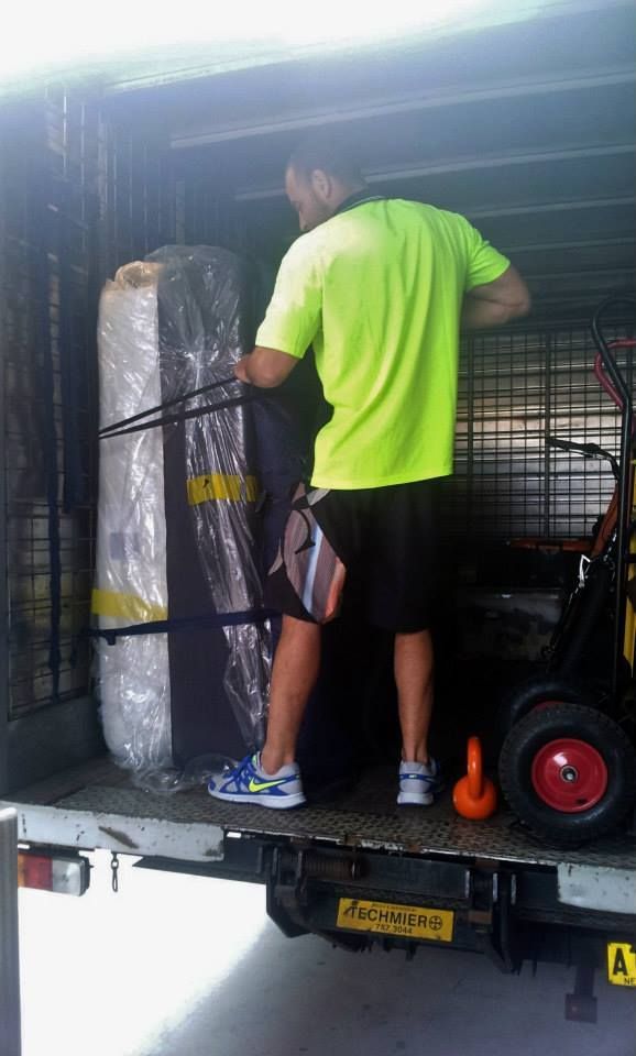 Man in Neon Green Shirt Unloading a Wrapped Mattress and Cage from A Truck — MM Removals In Nelson Bay, NSW