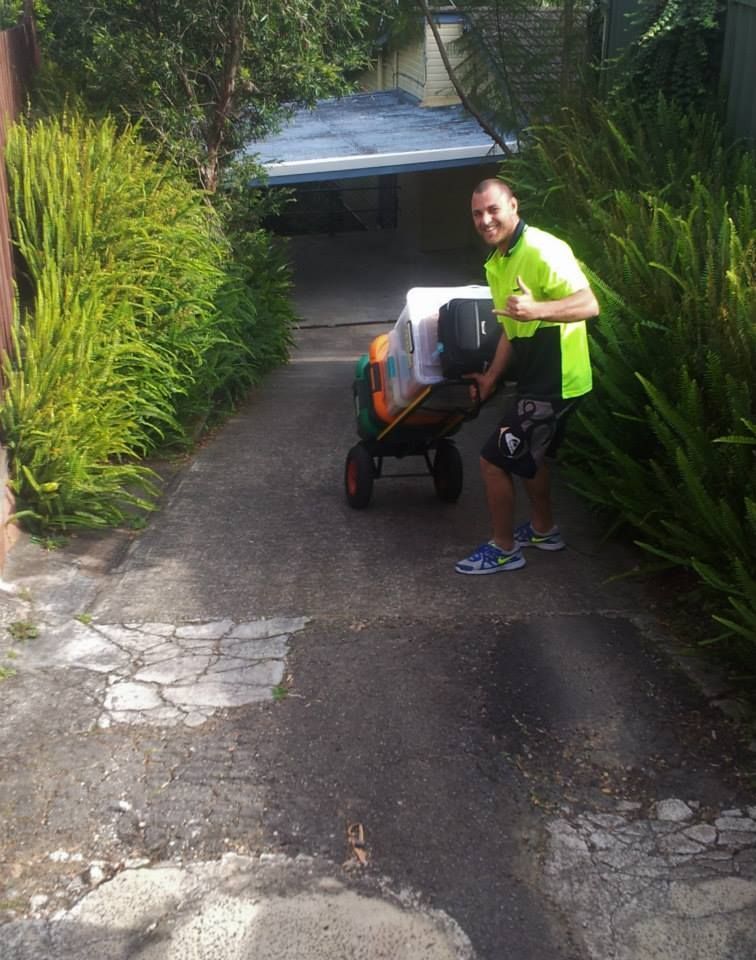 Person in A Neon Green Shirt Pushing a Stroller up A Driveway Beside Tall Greenery — MM Removals In Nelson Bay, NSW
